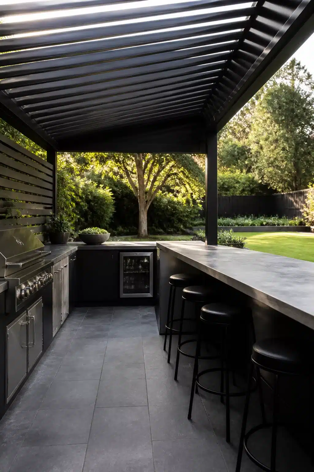 Black louvered metal pergola over outdoor kitchen with concrete bar — backyard shade ideas for modern entertaining