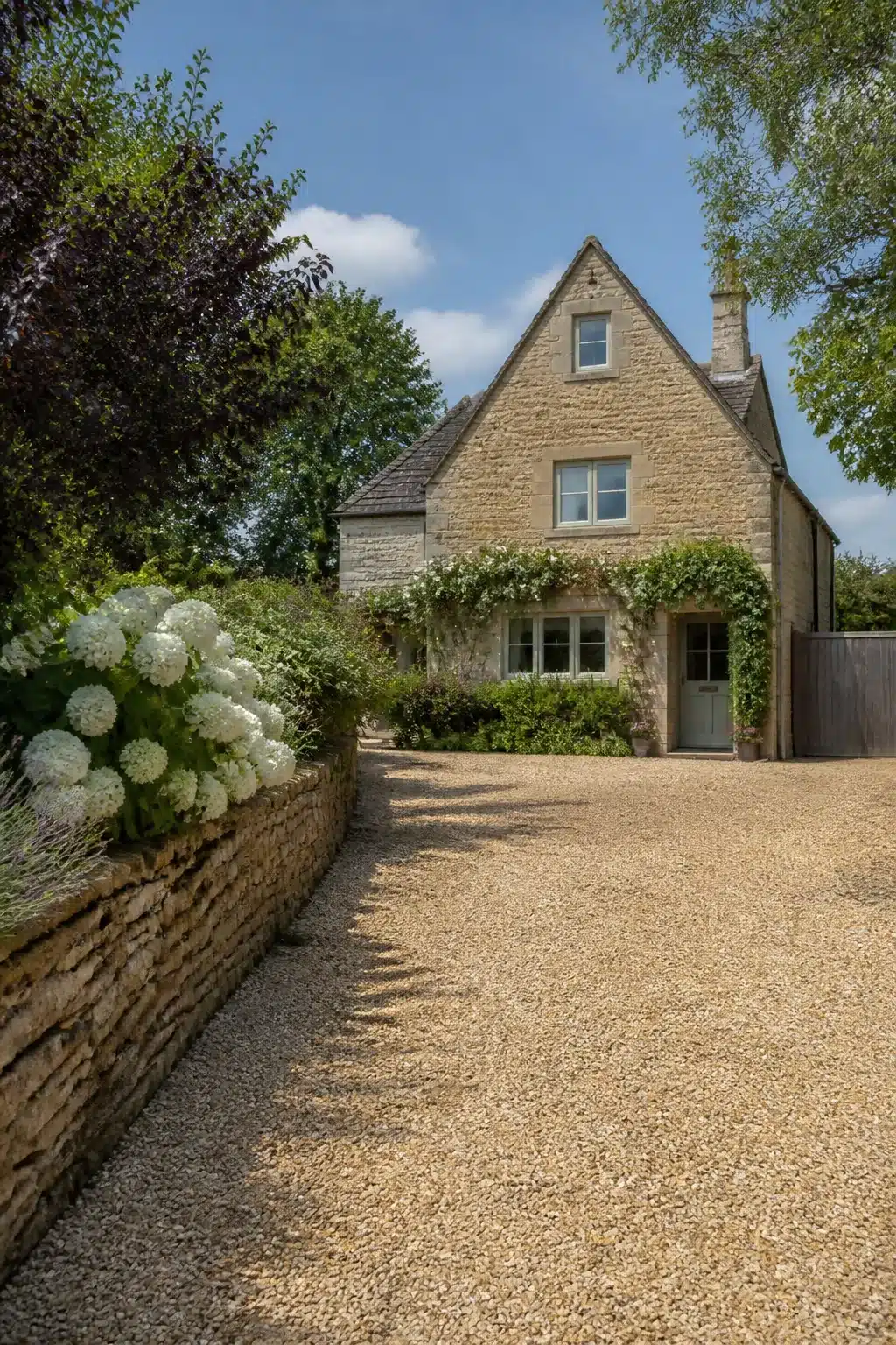 Cotswold stone cottage with honey gravel driveway and white hydrangeas — Gravel Driveway Ideas