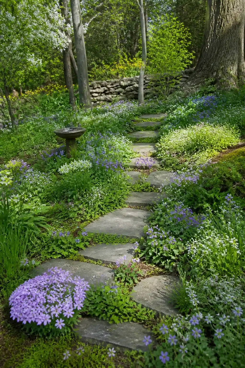 Flagstone stepping stone path through violet wildflowers in a natural wildlife garden — Wildlife Garden Ideas