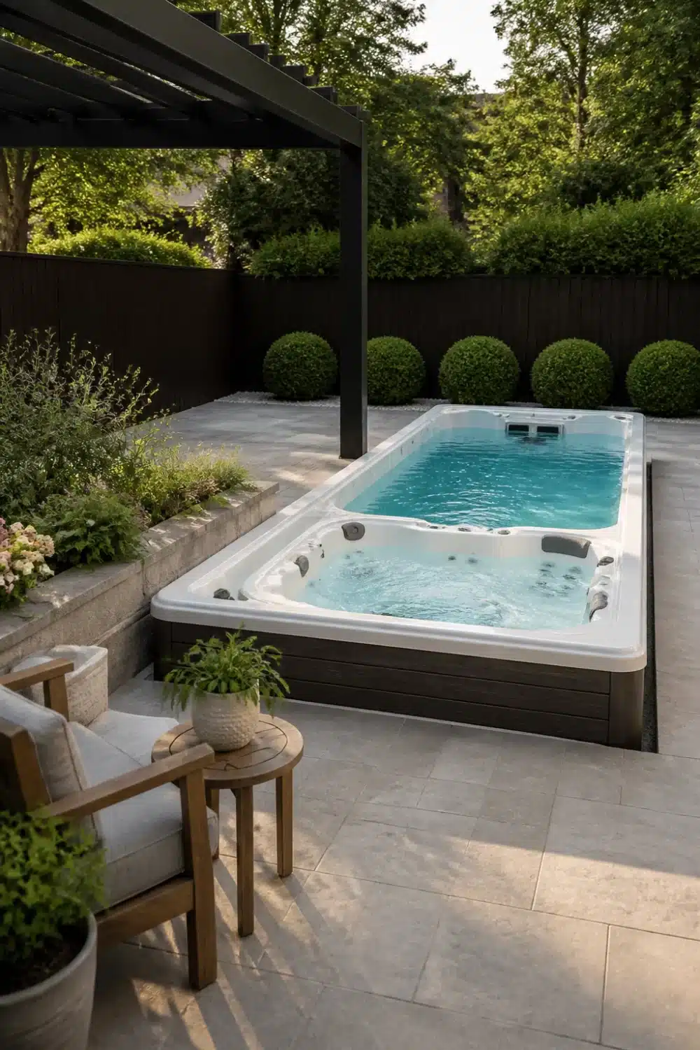 Backyard patio design with swim spa hot tub hybrid, limestone pavers, topiary balls and dark pergola