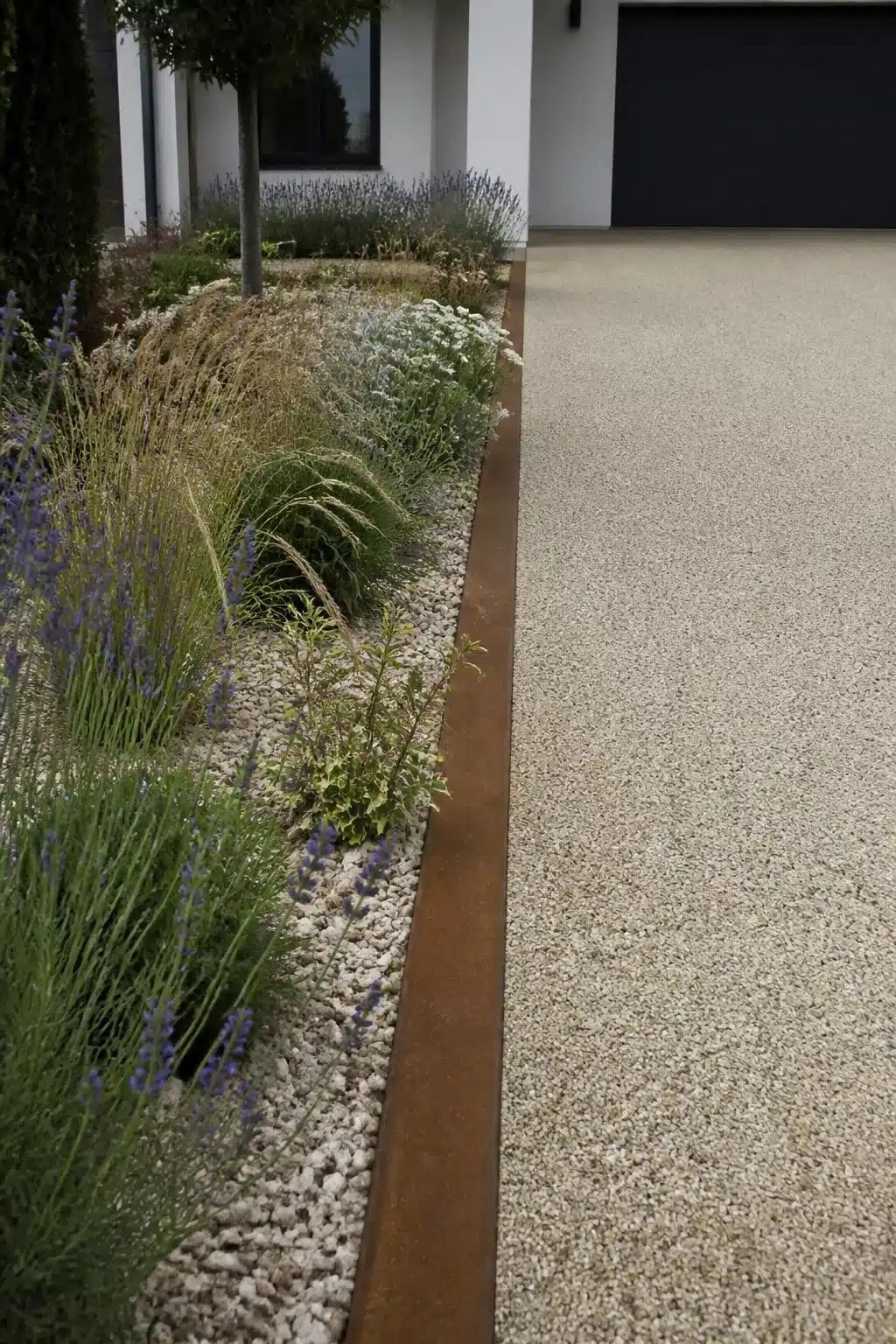 Corten steel driveway border edging with lavender and ornamental grass planting — driveway border ideas
