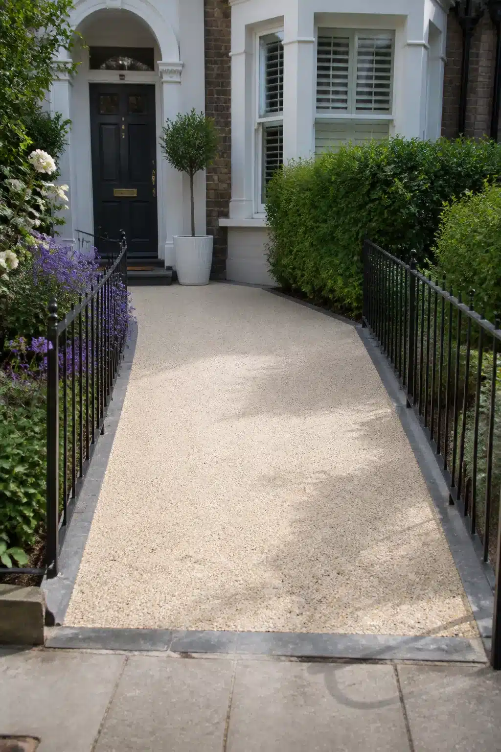 Pale beige resin driveway ideas for a small town front path with iron railings and bound aggregate surface