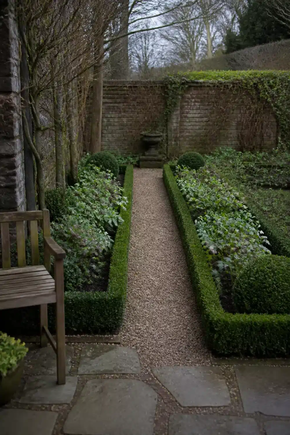 Symmetrical formal shade garden design layout with clipped box hedging, gravel path, and hellebore beds.